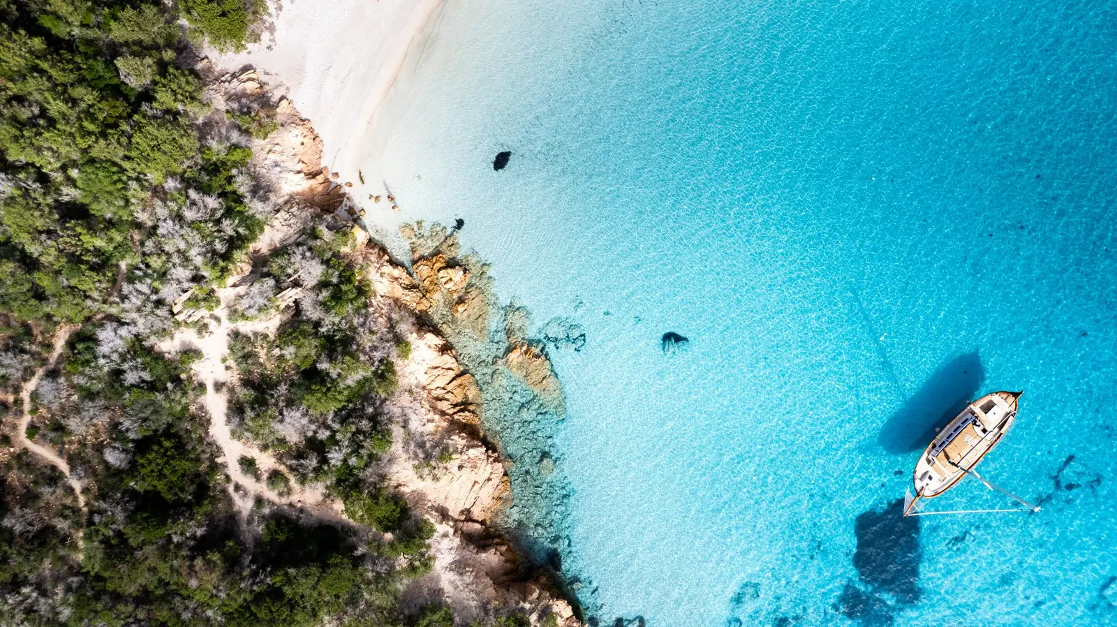 Acque turchesi dell'Arcipelago della Maddalena con il veliero Dolce Vita